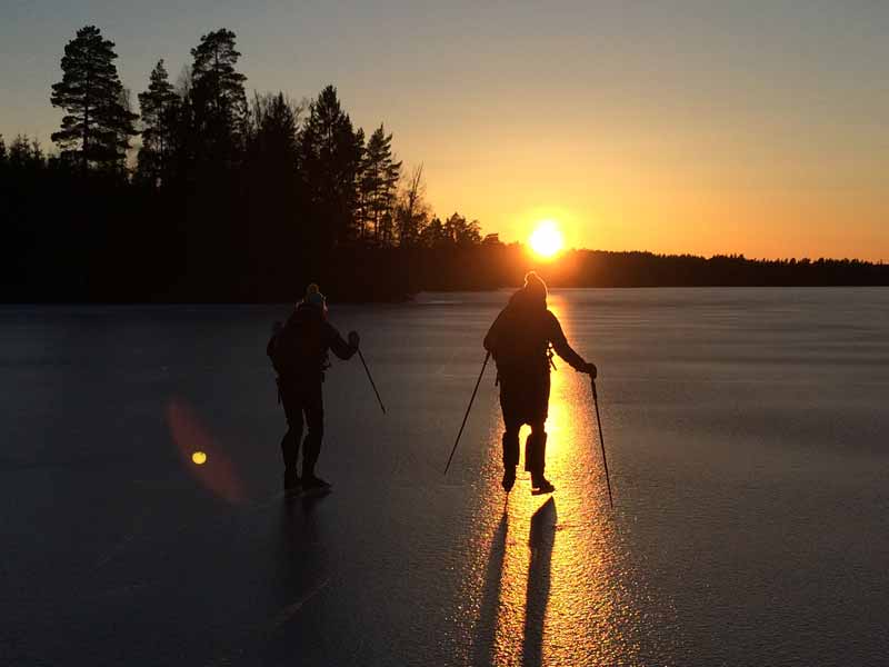 Ice skating on a frozen lake at sunset